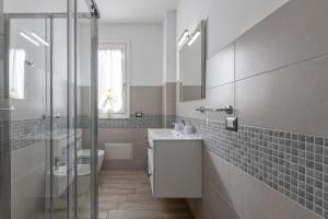 a bathroom with a sink and a toilet and a shower at Tirreno apartment in Alghero +12 photos