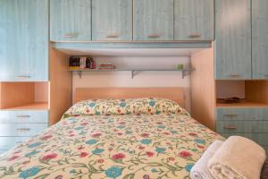 a bedroom with a bed with a floral bedspread at Attico vista mare Borgo La Palma 16 in Badesi