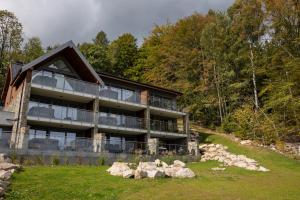 une maison sur une colline avec des rochers devant elle dans l'établissement Sky Hill Apartments Szklarska Poręba, à Szklarska Poręba