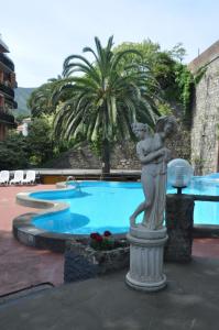 une statue d'une femme tenant un oiseau à côté d'une piscine dans l'établissement Appartamento Monolocale Moneglia 24, à Moneglia