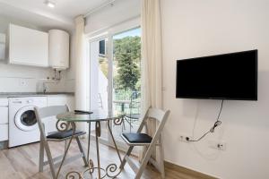 a kitchen with a table and chairs and a tv on a wall at Casa de 10 - 5a in Vejer de la Frontera