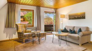 un salon avec un canapé, une table et des chaises dans l'établissement Ferienhaus Unmüßig, à Hinterzarten