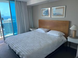 une chambre d'hôtel avec un lit et une grande fenêtre dans l'établissement Level 15 - Hilton Surfers Paradise, à Gold Coast