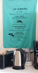 a sign on a kitchen counter with a tea kettle at Chez Nathou in La Teste-de-Buch