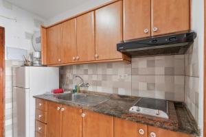 Una cocina con gabinetes de madera y un fregadero. en Studio vista piscina, en Maspalomas
