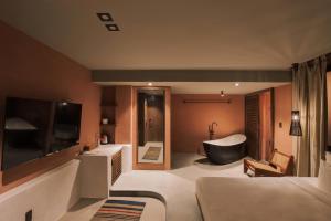 a bathroom with a tub and a bed and a bath room at The Aratana Villa in Da Lat