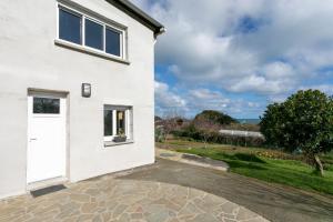 a white house with a white door and a driveway at Fusains 5 petit-déjeuner vue mer in Saint-Quay-Portrieux