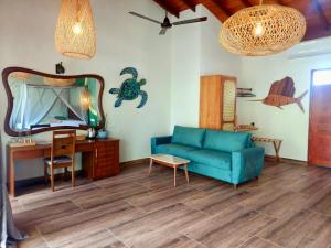 a living room with a blue couch and a mirror at Sri Palms in Kosgoda