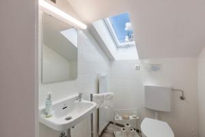 Un baño con lavabo, inodoro y ventana. en Ferienwohnung Haus Oehlberg, en Todtmoos 19 fotos más