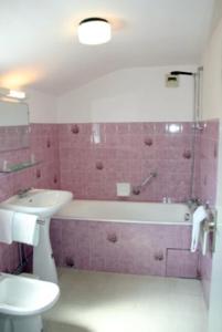 y baño con lavabo, bañera y aseo. en Hôtel du Marché, en Beauvoir-sur-Mer