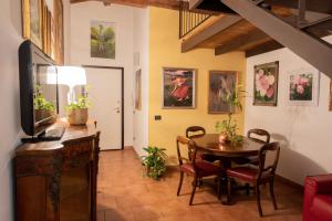 uma sala com uma mesa e cadeiras e uma televisão em Romantica Corte Degli Estensi em Ferrara