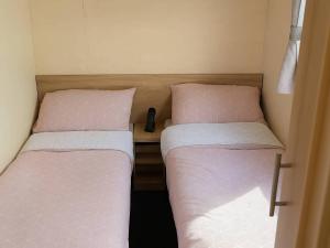 a pair of beds in a small room at Golden Gate Holiday Centre - Holiday Accommodation 19059 in Kinmel Bay