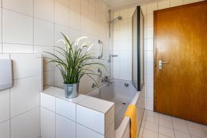 a bathroom with a tub and a plant on a counter at Möst in Sankt Märgen +10 photos