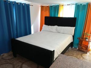 a bed in a room with colorful curtains at Thegreenhouse in Santiago de los Caballeros