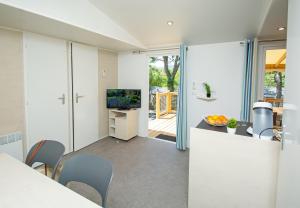 a kitchen with white cabinets and a counter with a television at Camping Sunelia L'Argentière in Cogolin