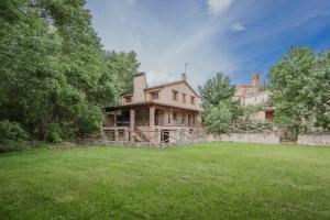 an old house with a large yard in front of it at Los Molinillos in Caballar