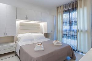 a bedroom with a bed with towels on it at Ricky's Luxury Apartment in Misano Adriatico