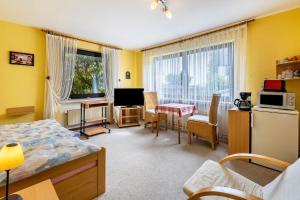 a bedroom with a bed and a kitchen with a table at Ferienwohnung Neuenrade in Neuenrade