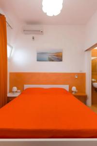 a bedroom with an orange bed and a bathroom at Luna Rossa Salento in Porto Cesareo +35 photos