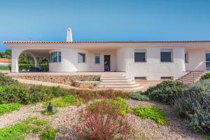 a large white house with a garden in front of it at Binicasal in Sant Lluis