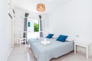 a white bedroom with two beds and a window at Apartamento Biniforcat 28 in Cala en Forcat +19 photos