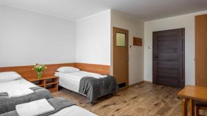 奥古斯图Krechowiak的一间卧室，有两张床和木地板