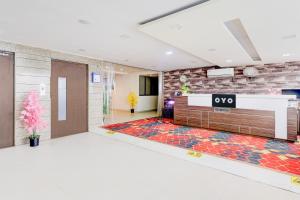 an office lobby with a reception desk and a brick wall at Hotel O Skyland in Ahmedabad
