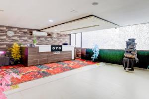 an empty lobby with a tile floor and a counter at Hotel O Skyland in Ahmedabad