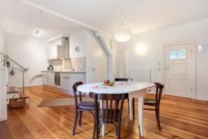 a kitchen and dining room with a white table and chairs at Alte Seifensiederei 2 in Stralsund +17 photos