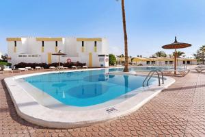 a swimming pool in front of a building at Bungalow Carpe Diem Capri in Maspalomas