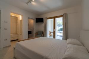 a bedroom with a large white bed and a window at Villa The Beach in Olbia