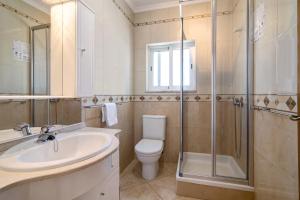 a bathroom with a toilet and a sink and a shower at Quarteira Beach ii in Quarteira +20 photos