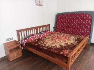een slaapkamer met een bed met een rode sprei bij Cherry Blossom in Kotagiri +17 foto's