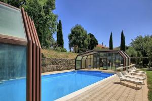 a house with a swimming pool and a glass house at Casale Mulino in Pancole