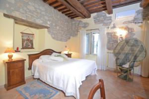 a bedroom with a bed and a stone wall at Casale Mulino in Pancole +32 photos