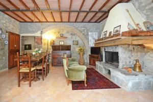a living room with a stone fireplace and a dining room at Casale Mulino in Pancole