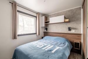 ein Schlafzimmer mit einem Bett mit einem Schild drauf in der Unterkunft Mobil-home Saint Jean de Monts in Saint-Jean-de-Monts + 15 Fotos