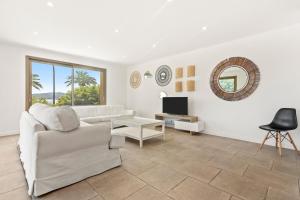 グリモーにあるVilla Capitaneのリビングルーム(白いソファ、テレビ付)