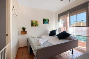 ein Bett in einem Zimmer mit einem großen Fenster in der Unterkunft Duplex Luminoso Campo de Golf in Islantilla + 16 Fotos