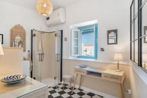 a bathroom with a shower and a desk and a sink at Casa Castillo con Jardín in Vejer de la Frontera +18 photos