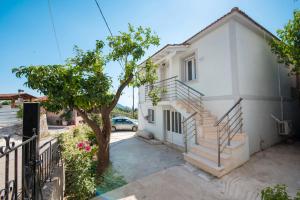 a white house with stairs next to a tree at Marianna's and Aristidis' houses in Sívros