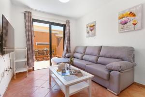 a living room with a couch and a table at Casa Miramar in Caleta De Fuste