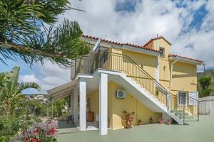 a large yellow house with a staircase at Palati in Ratzaklíon