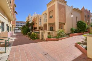 una pasarela de ladrillo frente a algunos edificios en Apartamento Mani, en Nerja