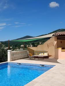 a swimming pool with a bench and a table at Maison de vacances avec piscine Var in Callas