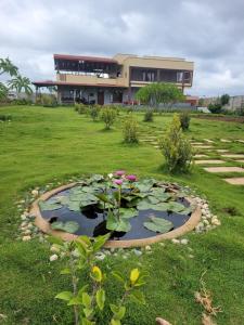 un estanque con lirios frente a un edificio en Elysian Hideaway By StayJade3BHKPoolGardenLawn, en Dodbelvangala