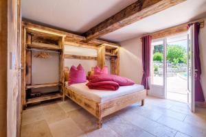 a bedroom with a bed with pink pillows on it at Domaine De La Plaine in Caille
