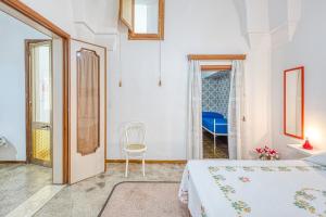 a bedroom with a bed and a chair and a window at Cod 278 al centro del paese in Ugento