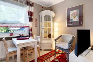 een woonkamer met een tv en een tafel en stoelen bij Bluehome Ferienwohnung in Bad Bellingen