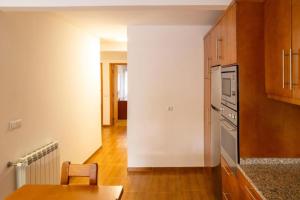 une cuisine avec une table et une cuisinière four supérieur dans l'établissement Retiro Da Montanha - Gerês, à Gerês